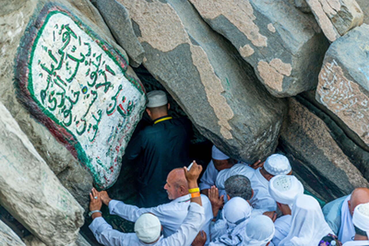 Peziarah di mulut Gua Hira' di Jabal an-Nur, dengan tulisan Arab di batu