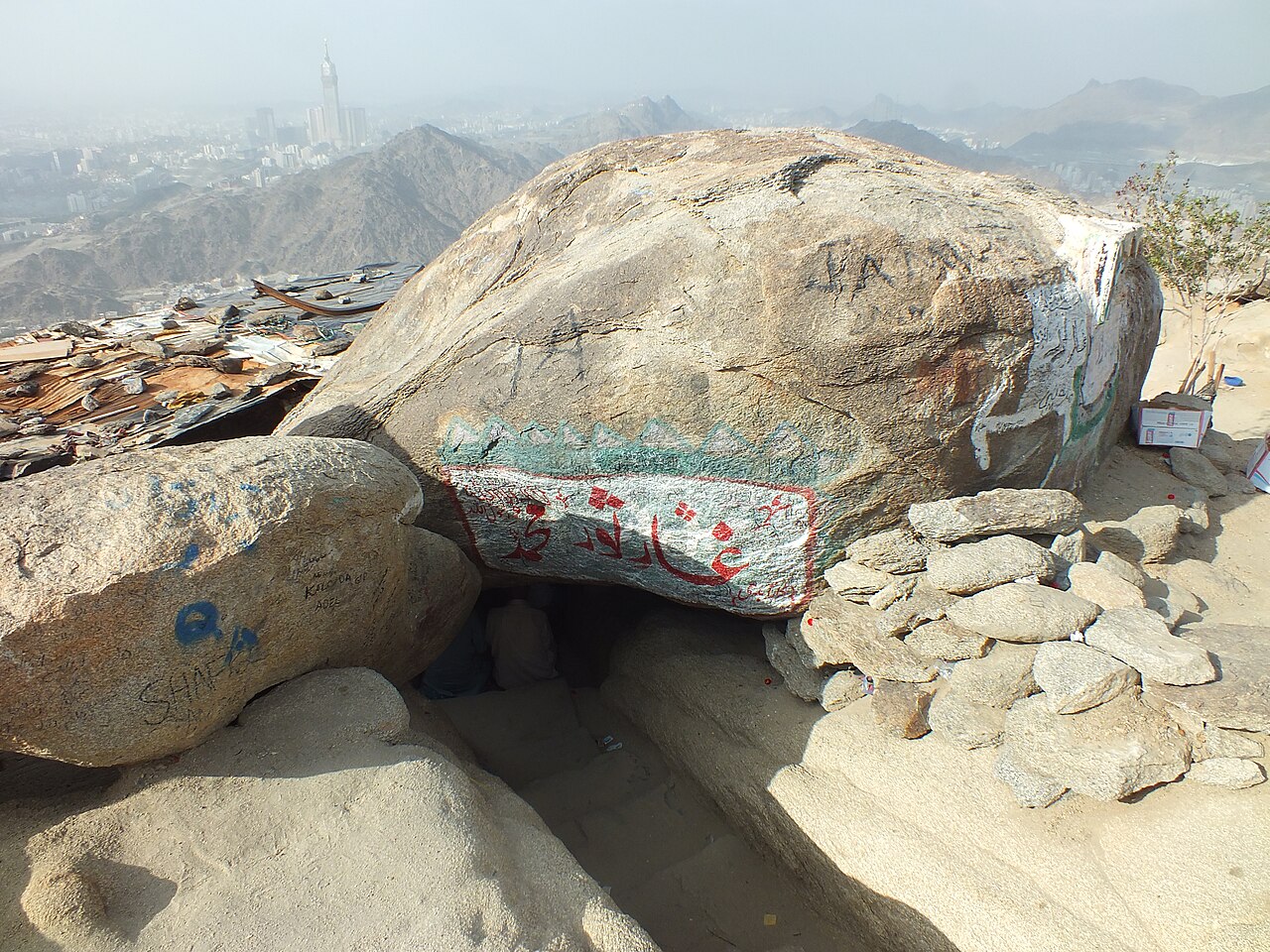 Gua Tsaur di puncak Jabal Tsaur, dengan tulisan Arab di batu dan kota Makkah di kejauhan